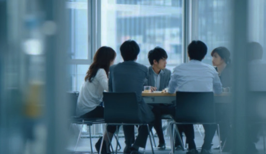テーブルを囲み、ともに仕事を進める人々